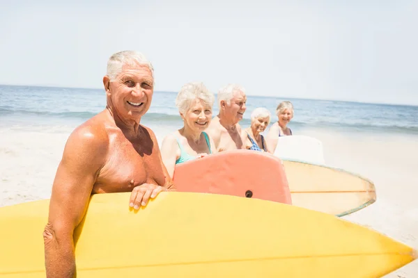 Senior vänner hålla surfbräda — Stockfoto