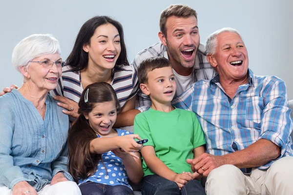 Lyckliga familjen tittar på TV — Stockfoto