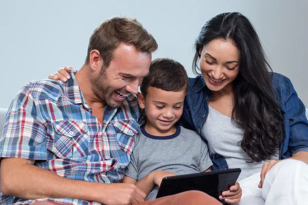Mãe, pai e filho olhando para tablet digital — Fotografia de Stock