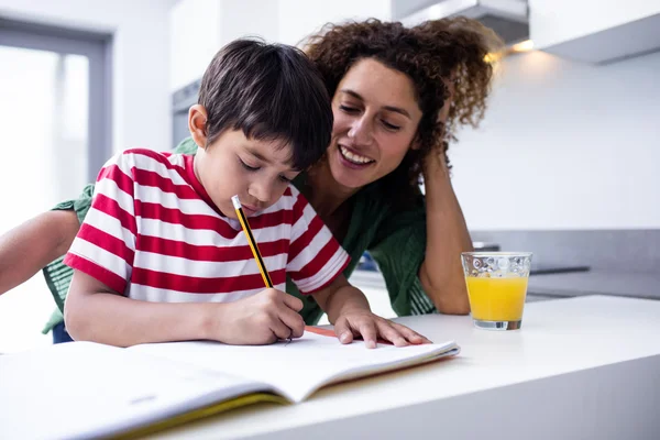 Moeder helpen zoon met huiswerk — Stockfoto