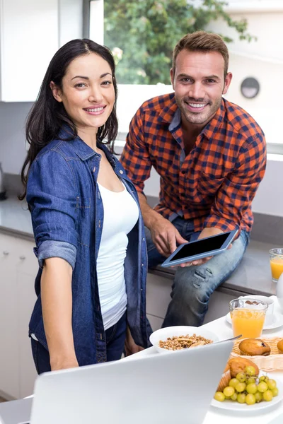 Young woman using laptop and man using digital tablet — Stock Photo, Image
