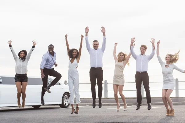 Välklädda människor hoppa bredvid en limousine — Stockfoto