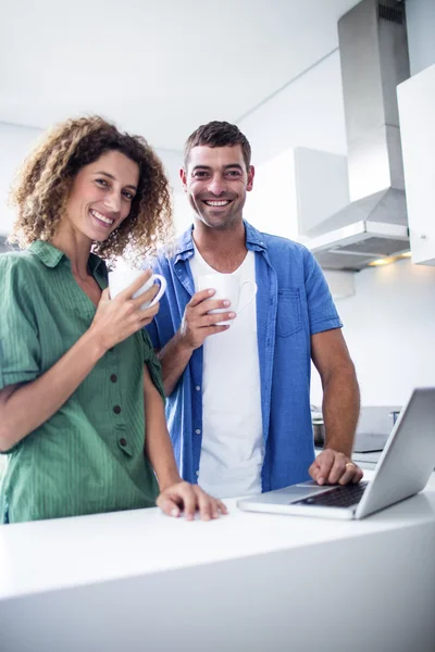 Πορτρέτο του ζευγάρι χρησιμοποιώντας φορητό υπολογιστή ενώ έχοντας ένα φλιτζάνι καφέ — Φωτογραφία Αρχείου
