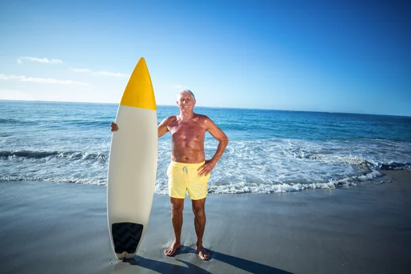 Homme âgé posant avec une planche de surf — Photo