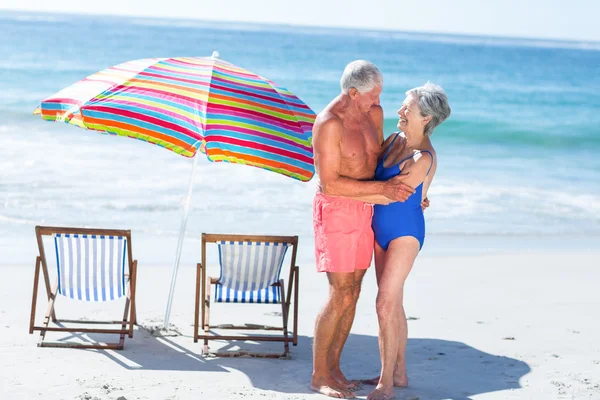 Söt äldre par kramas på stranden — Stockfoto