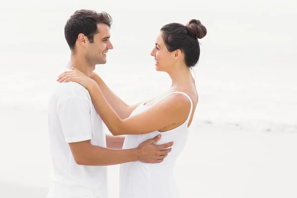 Gelukkige paar omhelzen elkaar op het strand — Stockfoto