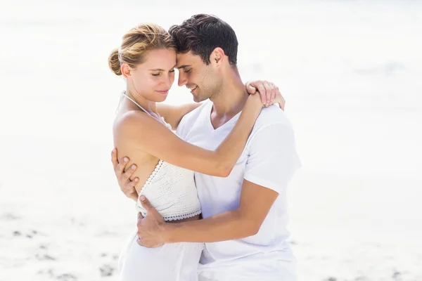 Молодая пара обнимается на пляже — стоковое фото