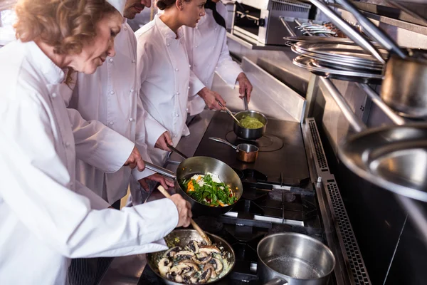 Gruppo di chef che prepara il cibo in cucina — Foto Stock