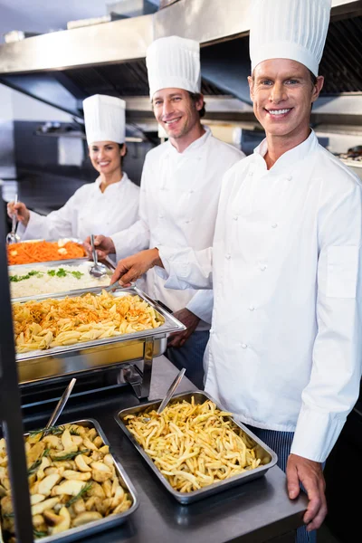 Chefs standing at serving trays of pasta — Stock Photo, Image
