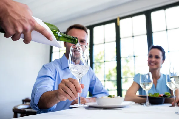 Kellner serviert Wein an eine Gruppe von Freunden — Stockfoto