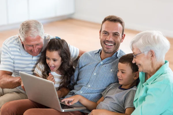 Happy family sitting on sofa — Stock Photo, Image