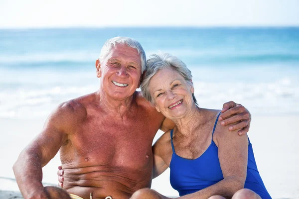 Leuk ouder paar zittend op het strand — Stockfoto
