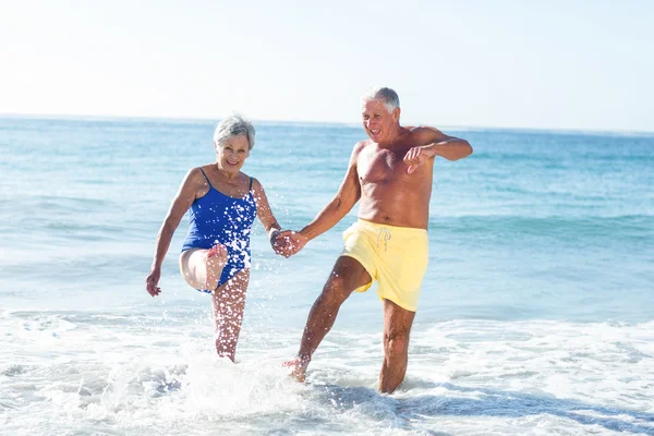 Äldre par leker med vågor — Stockfoto
