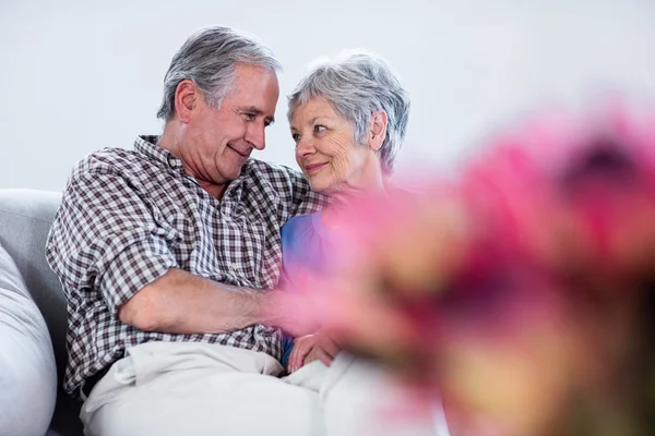 Šťastný starší pár objímat na pohovce — Stock fotografie