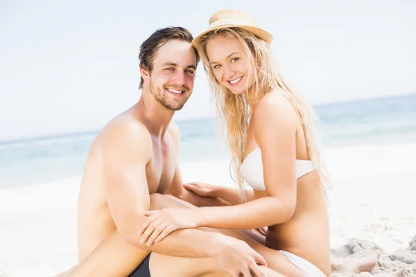 Portrait of young couple sitting together on the beach — Stock Photo, Image