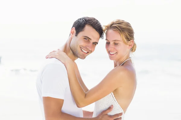 Pareja joven abrazándose en la playa — Foto de Stock