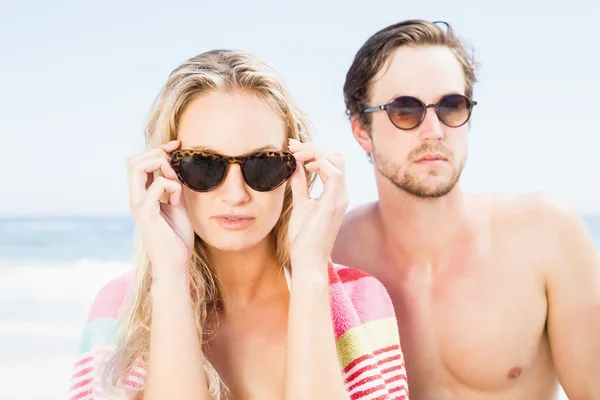 Jovem casal usando óculos de sol na praia — Fotografia de Stock