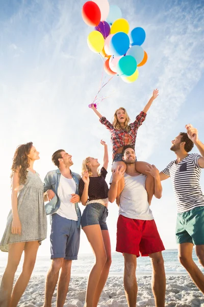 Vänner som poserar med ballong på sand — Stockfoto