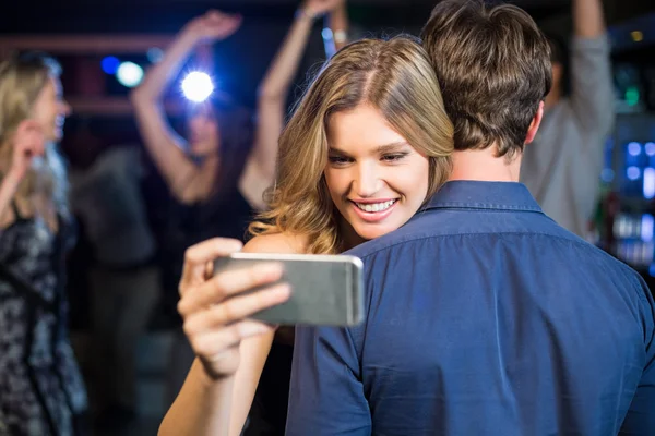Женщина использует смартфон, обнимая парня — стоковое фото