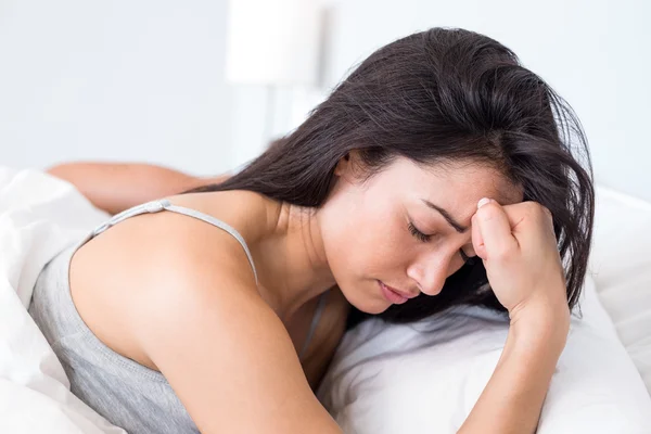 Mulher perturbada deitada na cama — Fotografia de Stock