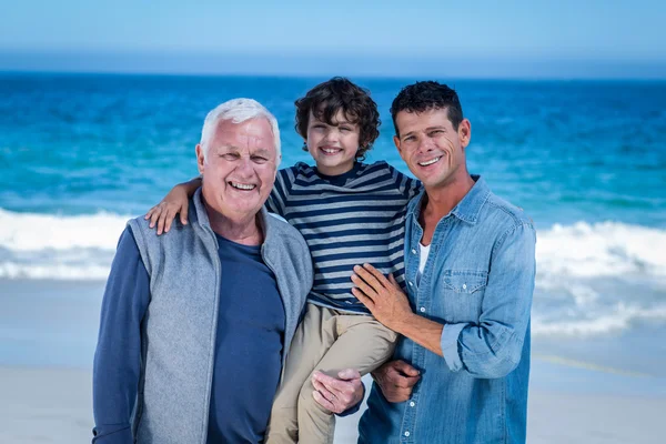 Manliga familjemedlemmar poserar på stranden — Stockfoto