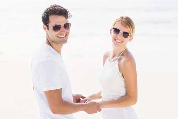 Ruce hospodářství romantický pár na pláži — Stock fotografie