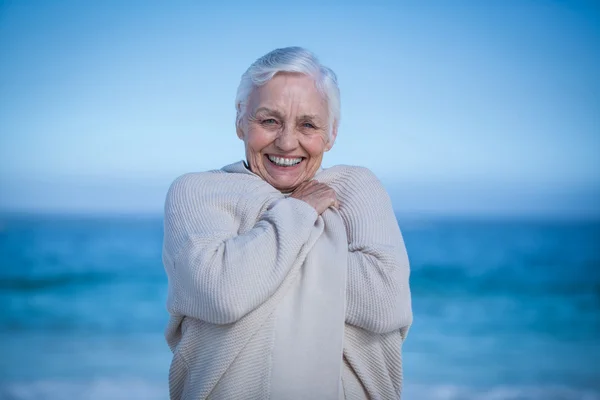 Senior vrouw glimlachend naar de camera — Stockfoto