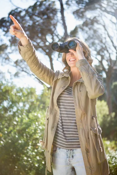 Woman using binoculars — Stock Photo, Image