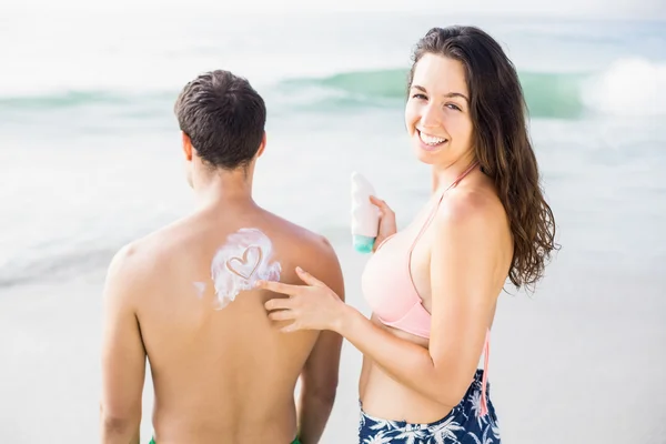 Woman making a heart symbol on mans back — Stock Photo, Image