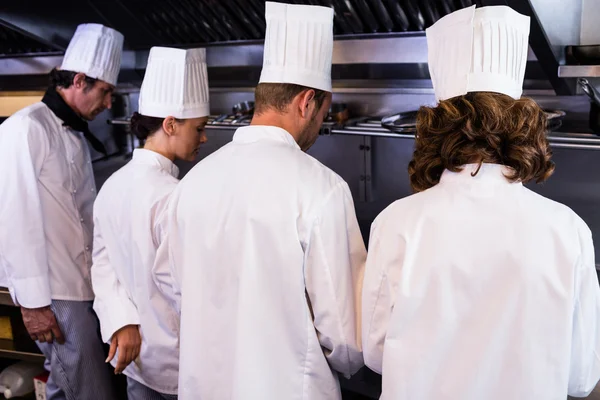 Köche bereiten Essen in der Küche zu — Stockfoto