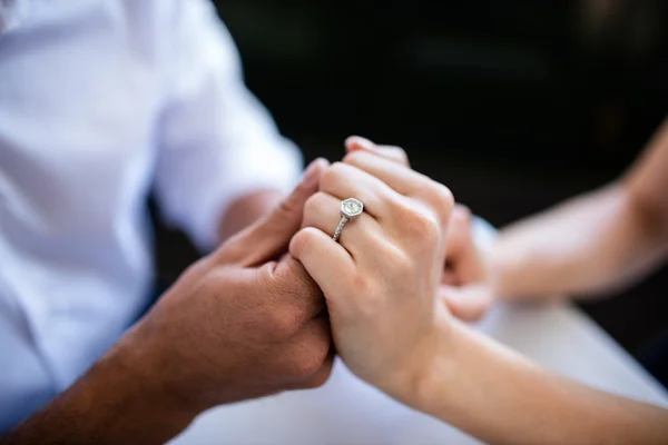 Paar hält Händchen mit Verlobungsring — Stockfoto