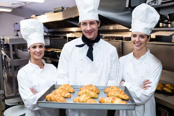 Chefs holding tray of baked croissants — Stock Photo, Image