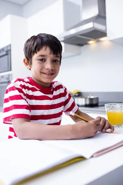 Chlapec dělat úkoly v kuchyni — Stock fotografie
