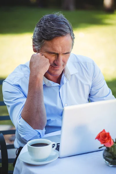 Casual homem de negócios usando laptop e tomar café — Fotografia de Stock