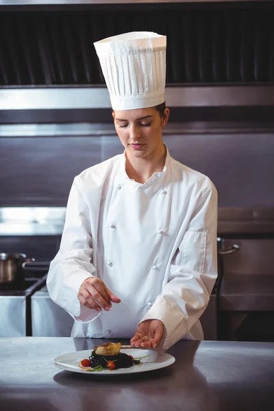 Koch streut Gewürze auf Teller — Stockfoto