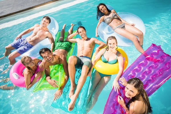 Glade venner nyder i swimmingpoolen - Stock-foto