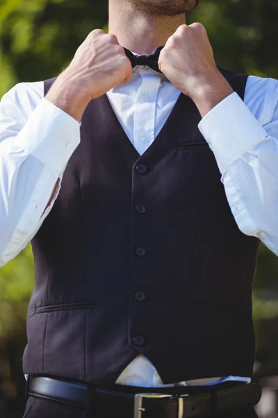 Handsome waiter reattaching his bow tie — Stock Photo, Image