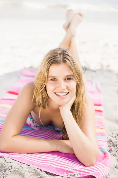 Portret van gelukkige vrouw in bikini, liggend op het strand — Stockfoto