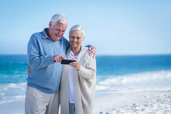 Ładny starsza para patrząc smartphone — Zdjęcie stockowe