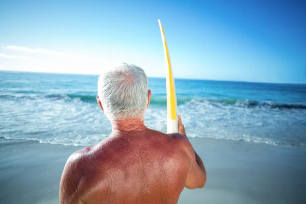 Homme âgé posant avec une planche de surf — Photo