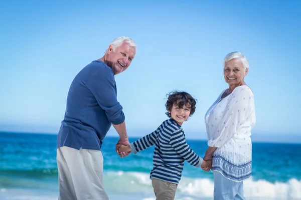 Mignon garçon tenant ses grands-parents mains — Photo