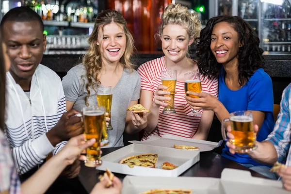 Amigos felices tomando una copa y pizza — Foto de Stock