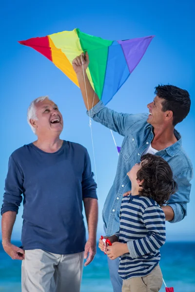 Familia feliz multi generación jugando con una cometa — Foto de Stock