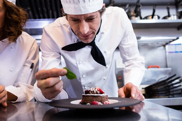 Chef che guarnisce dessert con foglia di menta — Foto Stock