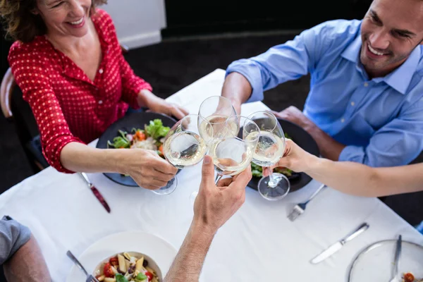 Freunde stoßen mit Weingläsern an — Stockfoto