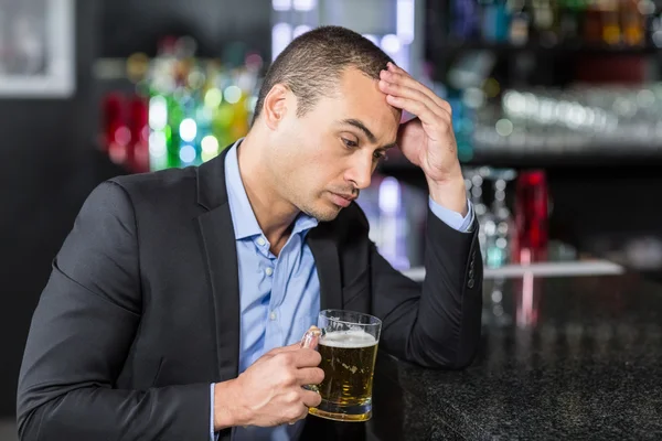 Worried businessman drinking a beer — Stock Photo, Image