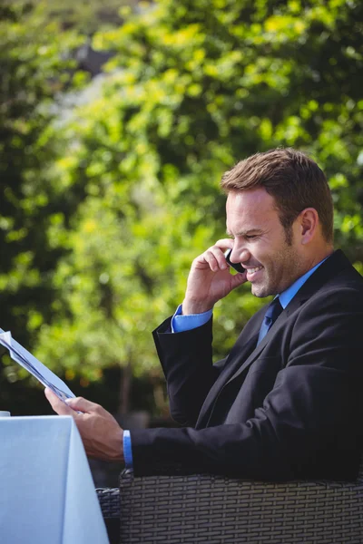 Affärsman på telefonen och läsa menyn — Stockfoto