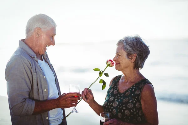 Старшая пара держит розовые и красные бокалы — стоковое фото