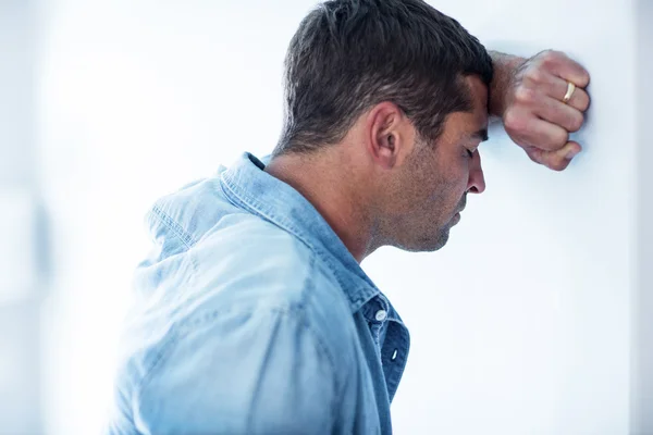 Boos man leunend op muur — Stockfoto