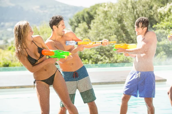 Amici felici che fanno battaglia pistola ad acqua — Foto Stock
